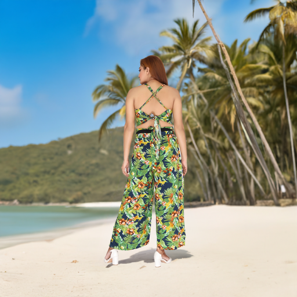 Back view of a tropical printed 100% rayon co-ord set featuring a halter-style tie-up top and wide-leg pants, displayed on a sunny beach.