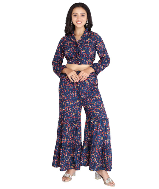 Front view of a high-quality polyester co-ord set featuring a printed crop top with ruffle details and tiered flared pants.